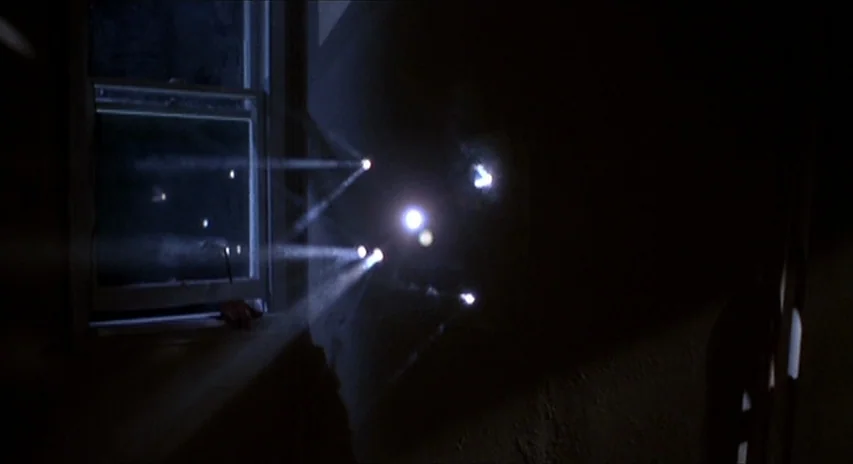 Blood Simple (1984) movie still: wide — A dark interior wall shows multiple distinct beams of white light entering the space. These light rays…