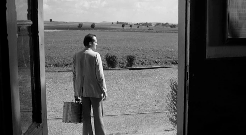 Kings of the Road (Im Lauf der Zeit) (1976) movie still: fullbody — A man stands in the doorway of a simple building looking toward a field. The…