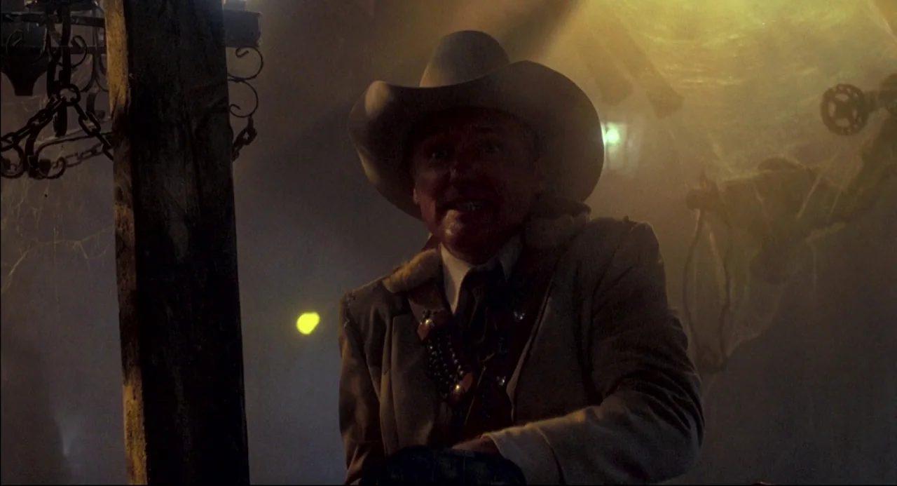 The Texas Chainsaw Massacre 2 (1986) movie still: medium — An attic space filled with dust and spiderwebs is illuminated by a single light. An…