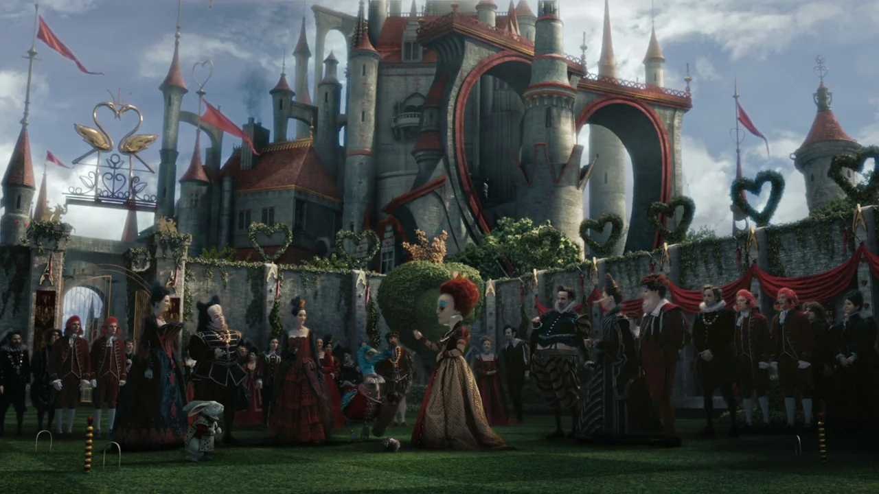 Alice in Wonderland (2010) movie still: wide — A stone courtyard features a tall castle with red-tiled towers and heart-shaped arches. The Red Queen…