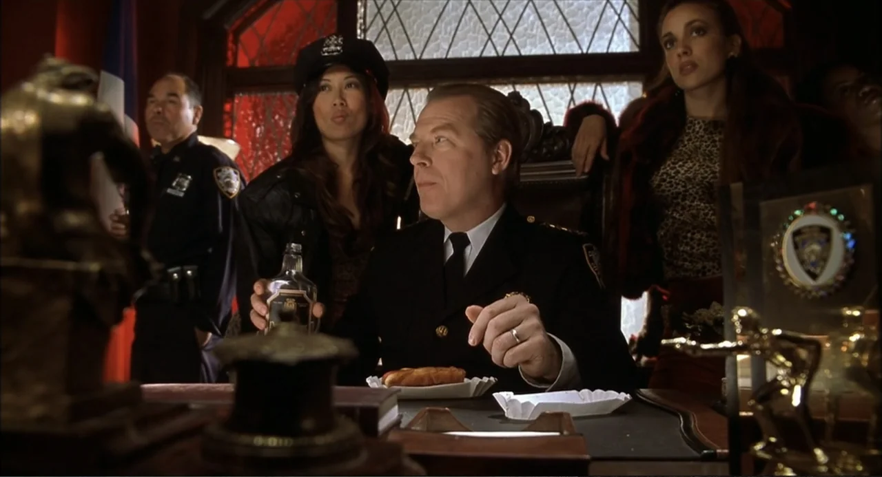 Little Nicky (2000) movie still: medium — A wood-paneled room with a large patterned window in the background containing police personnel. A man in…