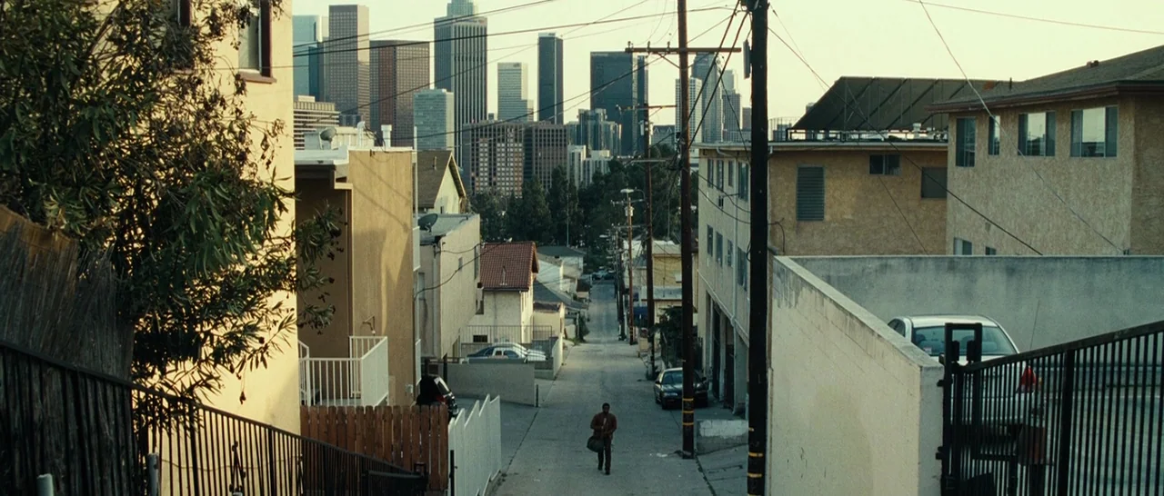 Message From The King (2016) movie still: wide — A quiet residential street in Los Angeles features low-rise apartment buildings and power lines. A…