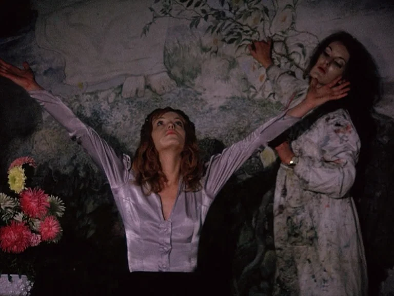 Der Bomberpilot (1970) movie still: medium — A dark indoor space featuring a large painted mural on the wall depicting foliage. One woman in a…