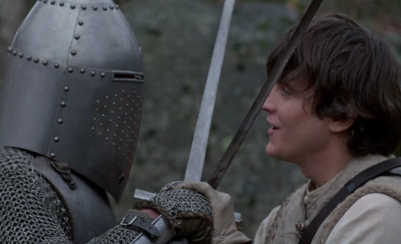 Blanche (1971) movie still: medium — A field serves as the backdrop for a tense confrontation between two individuals. A knight in full plate armor…