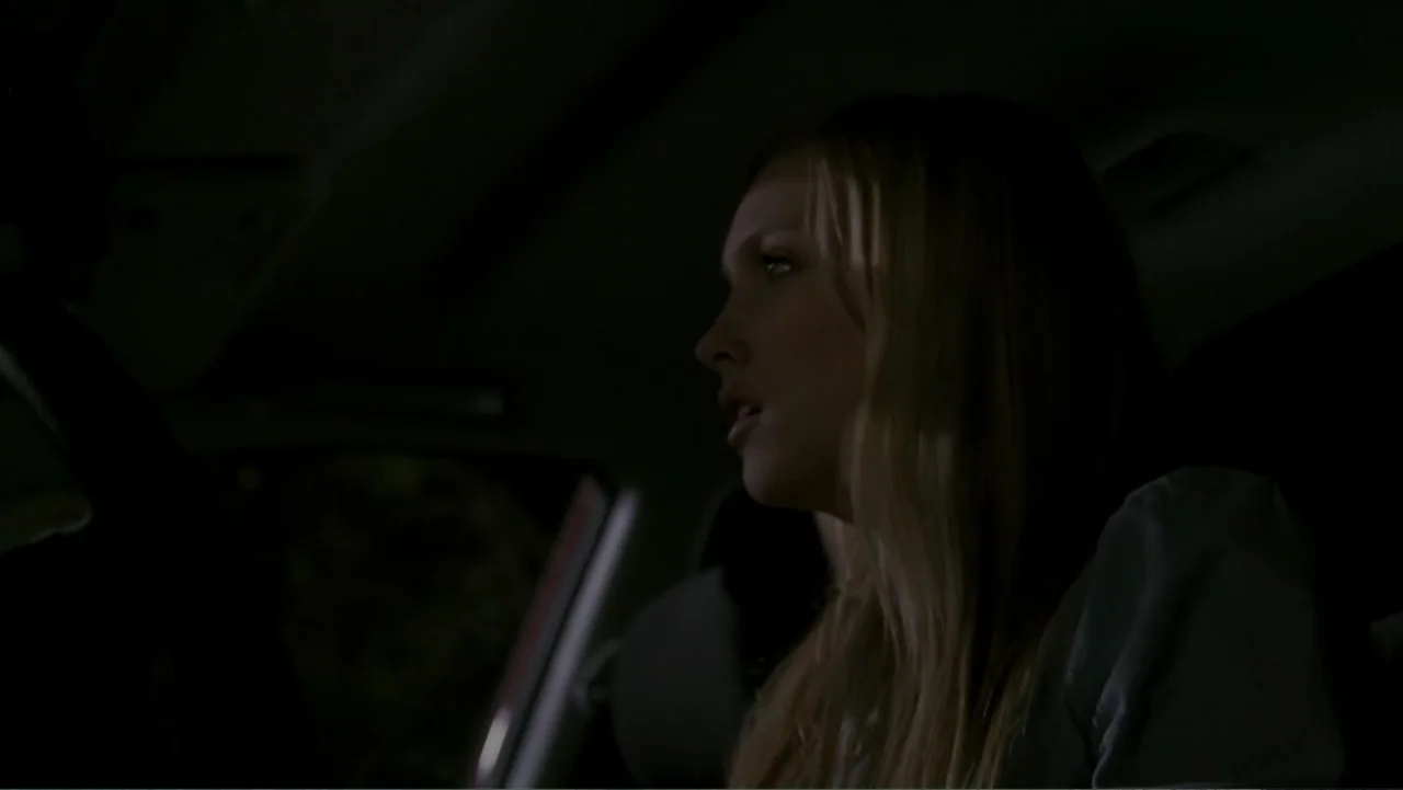When a Stranger Calls (2006) movie still: medium — A dark car interior at night with a woman seated behind the steering wheel. She looks forward…