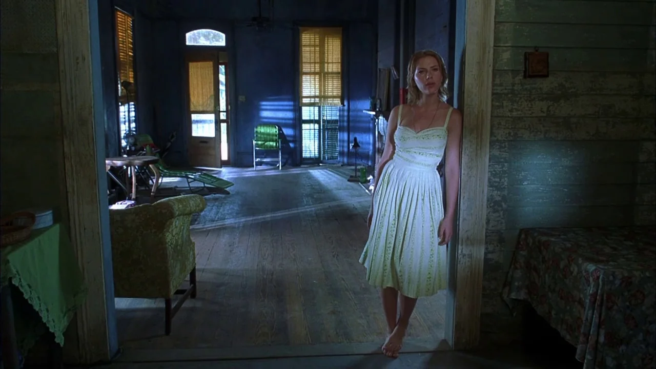 Love Song For Bobby Long (2004) movie still: fullbody — A spacious room features blue walls, wooden floors, and furniture arranged near…