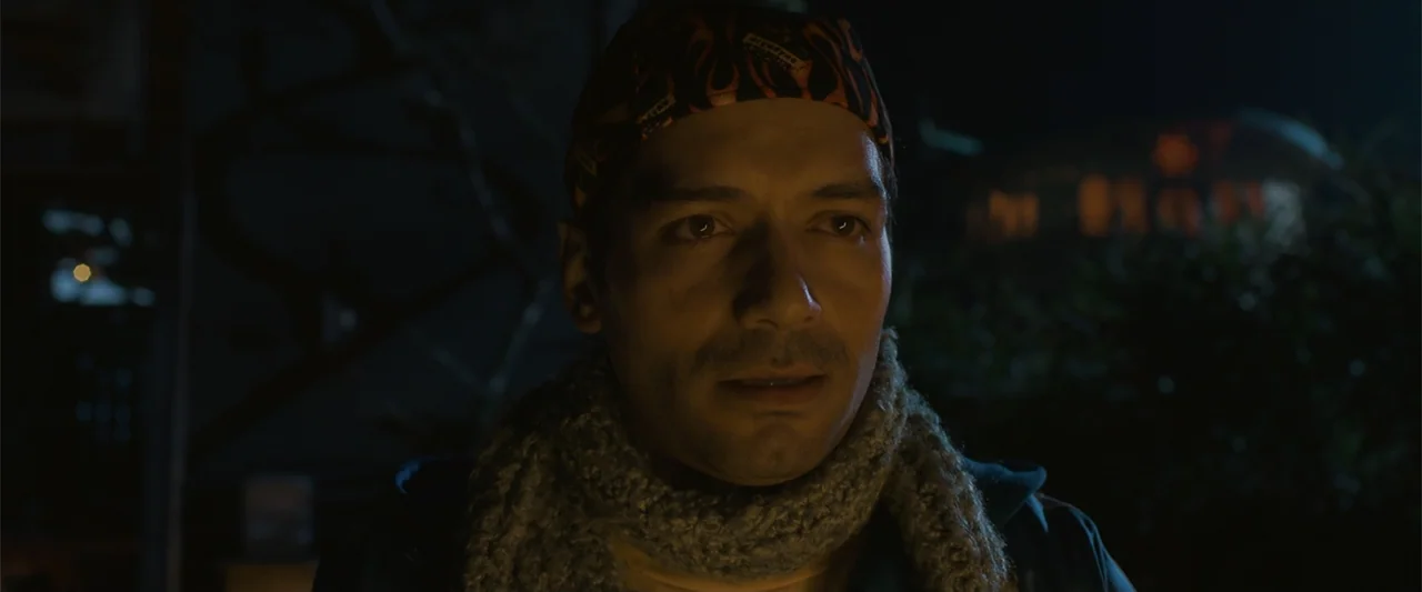 Mirreyes contra Godínez 2: El retiro (2022) movie still: closeup — An outdoor city setting at night with a blurred dark background. A man wearing a…