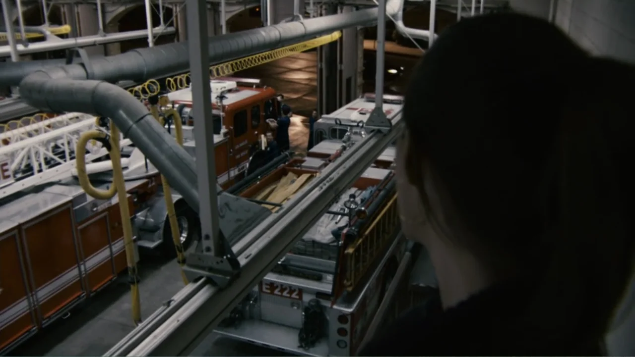 Quarantine (2008) movie still: medium — A high-angle view looks down from a mezzanine into a large industrial garage space. A person in the…