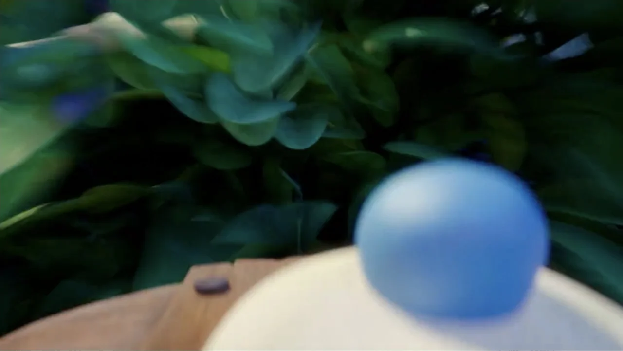Smurfs: The Lost Village (2017) movie still: closeup — A dense patch of green leafy plants fills the background behind a blurred object. A smooth…