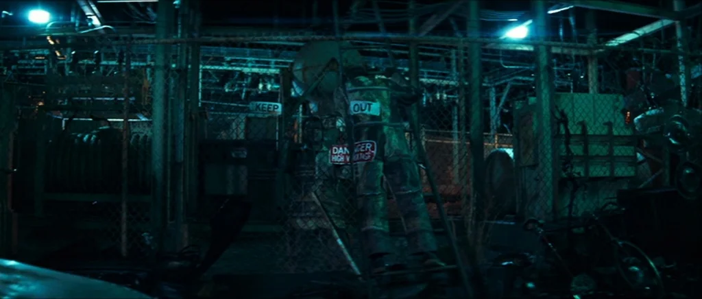 Be Kind Rewind (2008) movie still: wide — An outdoor electrical substation is surrounded by heavy chain-link fencing at night. A KEEP OUT sign is…