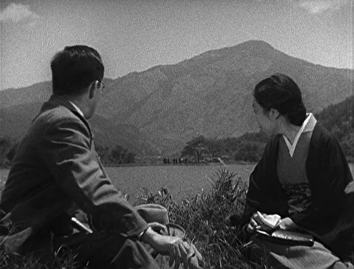 No Regrets for Our Youth (1946) movie still: medium — A man and a woman sit in tall grass facing a distant mountain range. They look out over the…
