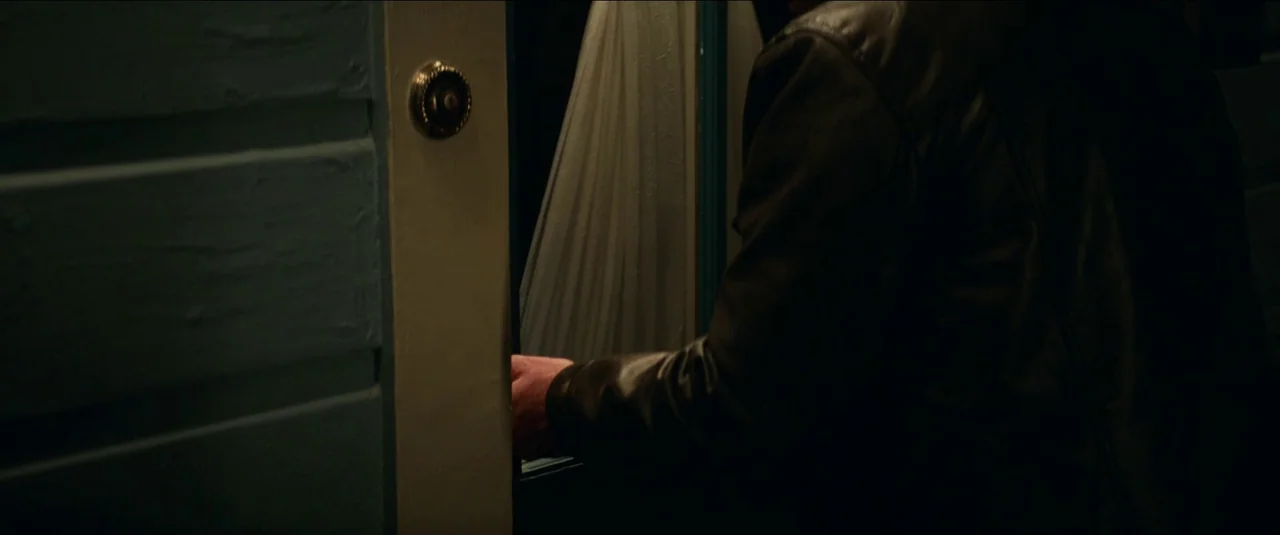 Halloween Kills (2021) movie still: medium — A dark exterior doorway features a blue painted wooden frame and a metallic knob. A person wearing a…