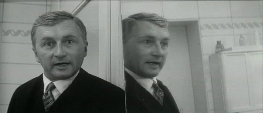 And The Fifth Horseman is Fear (1965) movie still: closeup — A tiled bathroom with a cabinet and a large mirror attached to the wall. A middle-aged…
