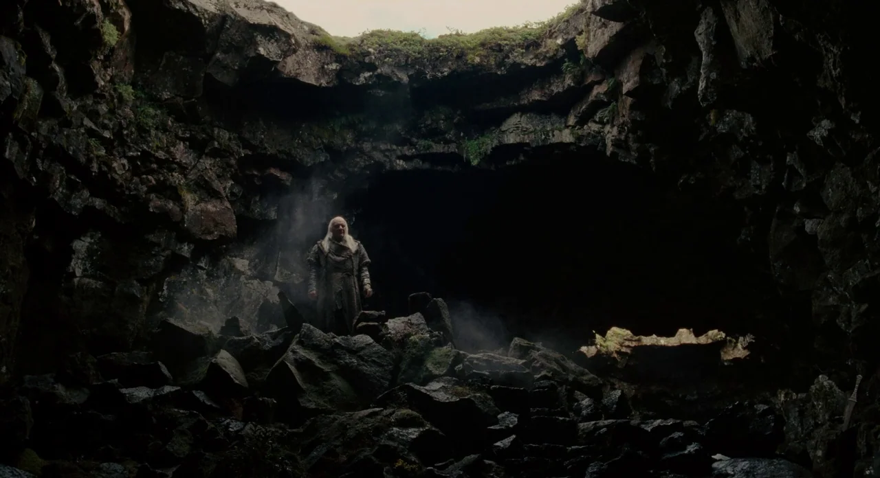 Noah (2014) movie still: wide — A vast volcanic cavity formed by jagged, moss-covered basalt rocks and shadows. An elderly man with long white hair…