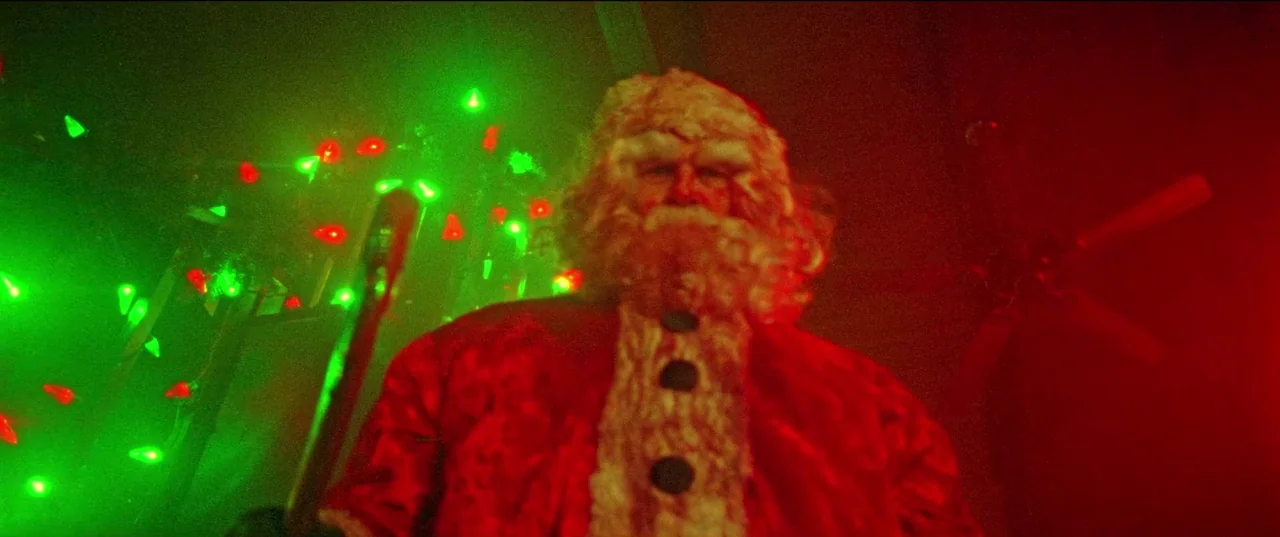 Christmas Bloody Christmas (2022) movie still: medium — An interior space is illuminated by intense red and green Christmas light decorations. A…