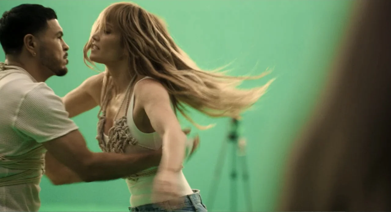 The Greatest Love Story Never Told (2024) movie still: medium — A green screen studio featuring a dancing couple against a flat, uniform digital…
