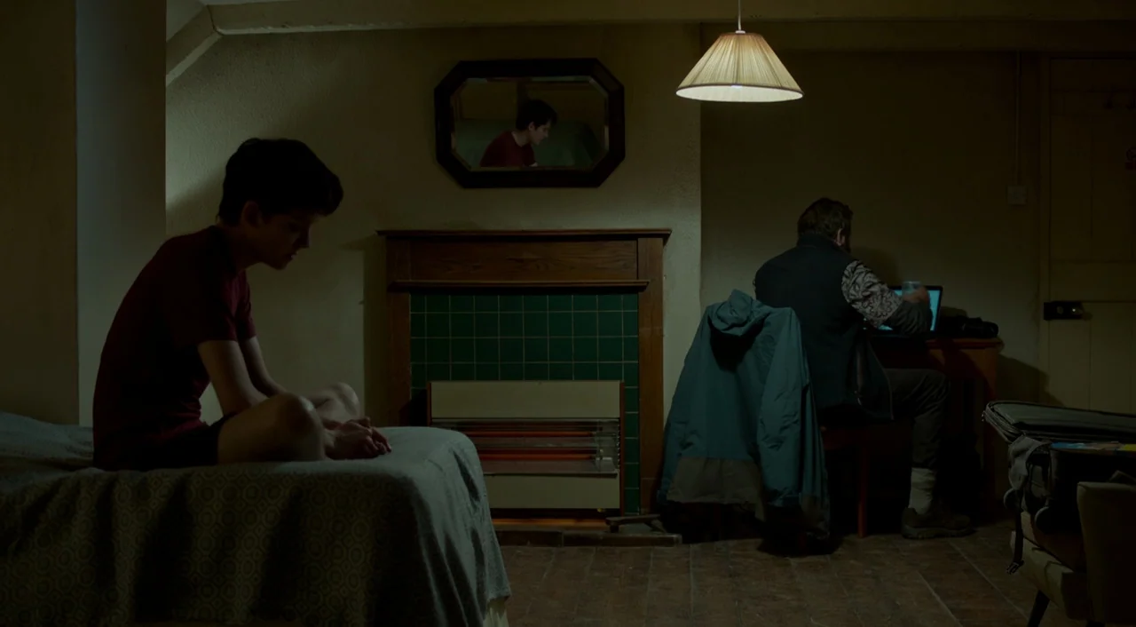 Miss Peregrine’s Home for Peculiar Children (2016) movie still: medium — A sparsely furnished room contains a bed, a fireplace with a mirror, and a…