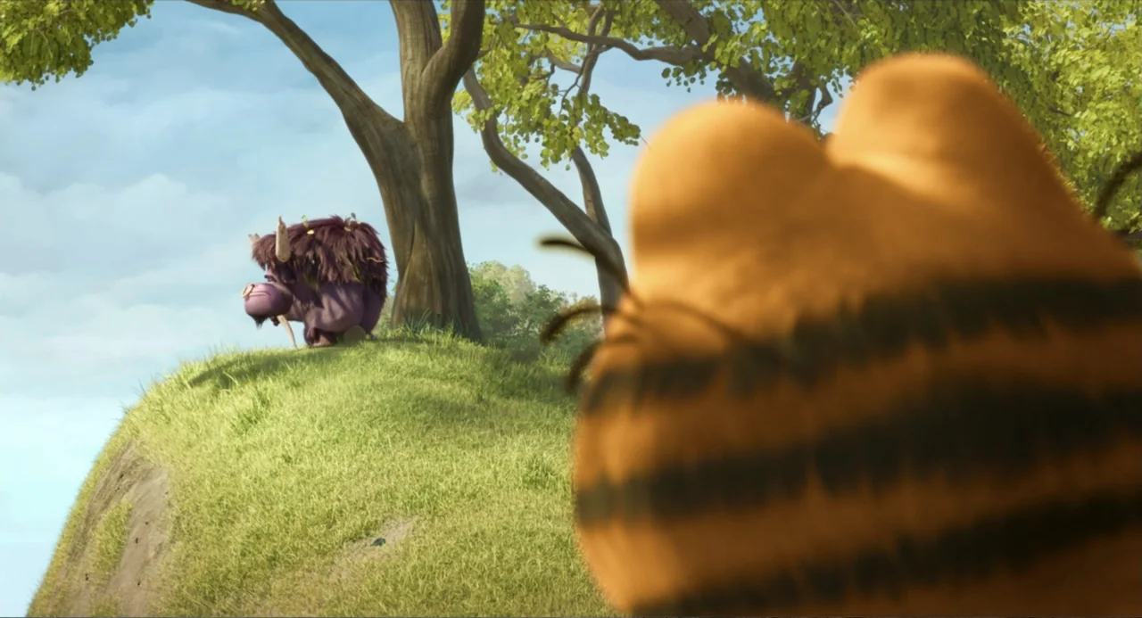 The Garfield Movie (2024) movie still: medium — A sunny grassy hillside with a large tree features a small purple creature standing. A blurry orange…