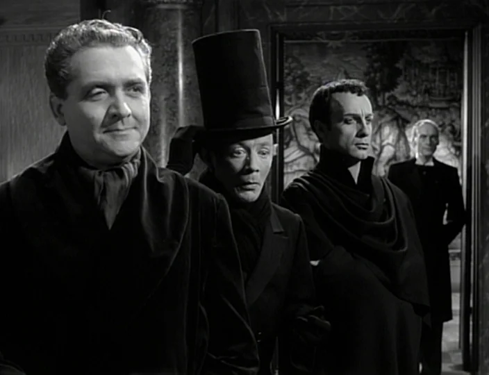 The Devil’s Eye (1960) movie still: medium — An interior space features three men in dark clothing standing in a row foreground. A fourth man waits…