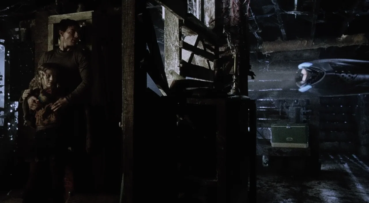 War of the Worlds (2005) movie still: wide — A dimly lit basement interior features exposed wooden beams and draped cobwebs throughout. A man holds…