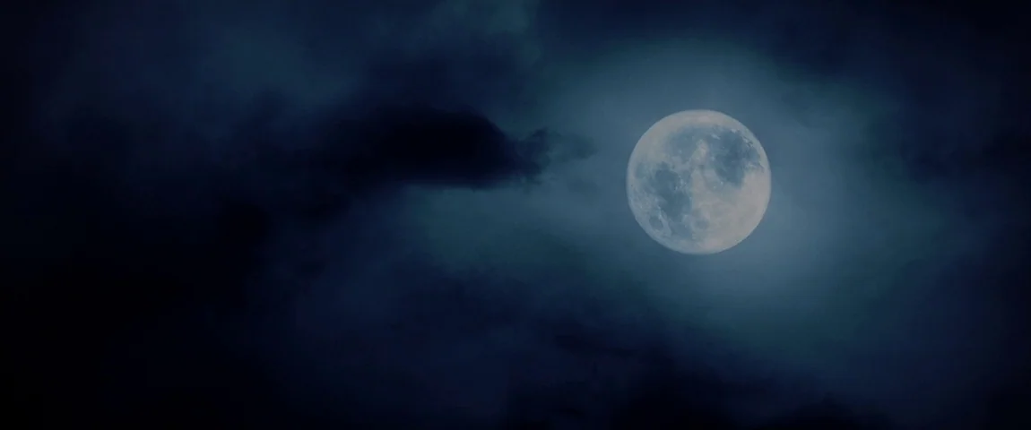 The Passion of the Christ (2004) movie still: establishing — A full moon shines brightly through a thick, dark layer of moving clouds. The night sky…