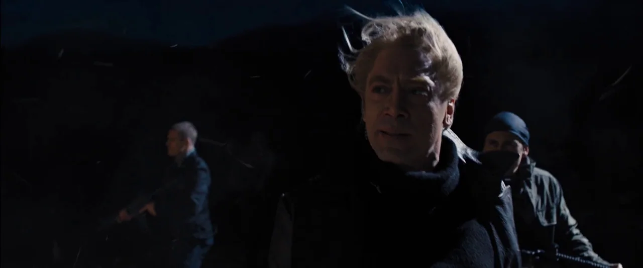 Skyfall (2012) movie still: medium — A dark, nighttime exterior landscape with faint moonlight illuminating a small group of men. A man with…