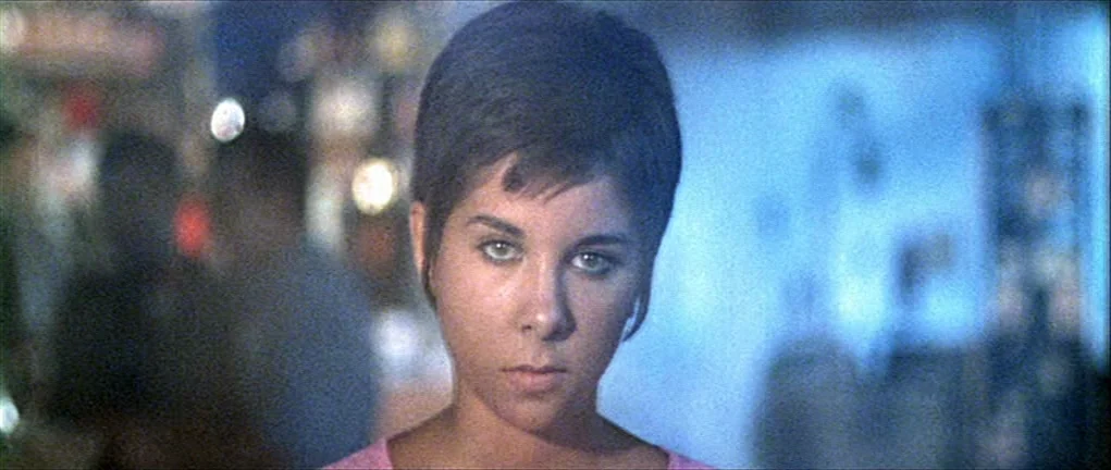 Two or Three Things I Know About Her (2 ou 3 choses que je sais d’elle) (1967) movie still: closeup — A dimly lit space with blurred, out-of-focus…