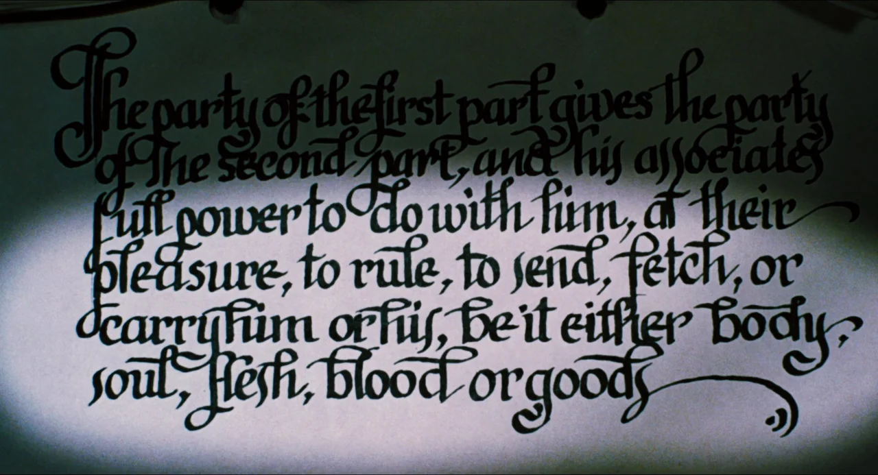 Phantom of the Paradise (1974) movie still: closeup — A close-up of a document featuring ornate, calligraphic black ink on cream-colored paper. The…