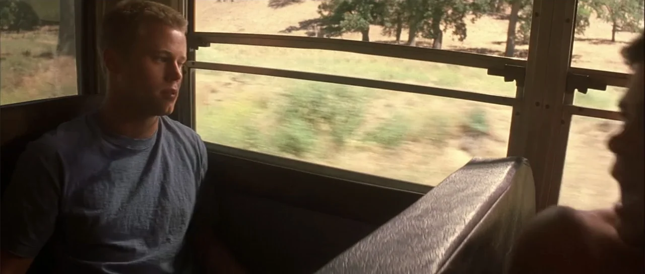 Jeepers Creepers 2 (2003) movie still: medium — A view from inside a moving bus looking at the interior and passing landscape. A young man sits in a…