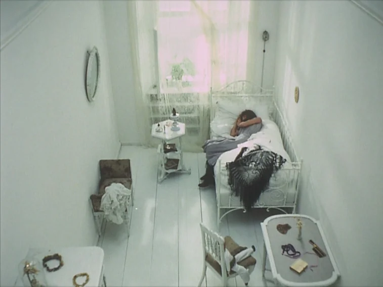 Valerie & Her Week of Wonders (1970) movie still: wide — A narrow, white-painted room contains a small iron bed and simple wooden tables. A person…