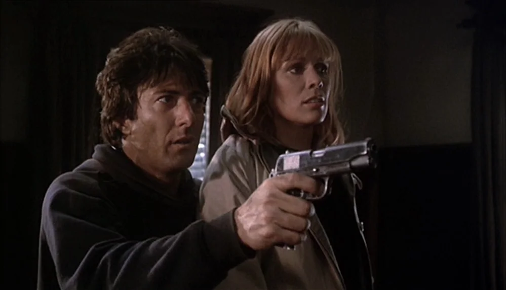 Marathon Man (1976) movie still: medium — A dark indoor space with minimal ambient light and shadowed walls. A man and woman stand together while…