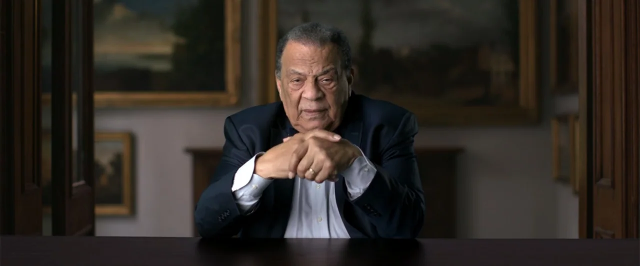 All In: The Fight for Democracy (2020) movie still: medium — An interior study with framed paintings hanging on light-colored walls behind a dark…
