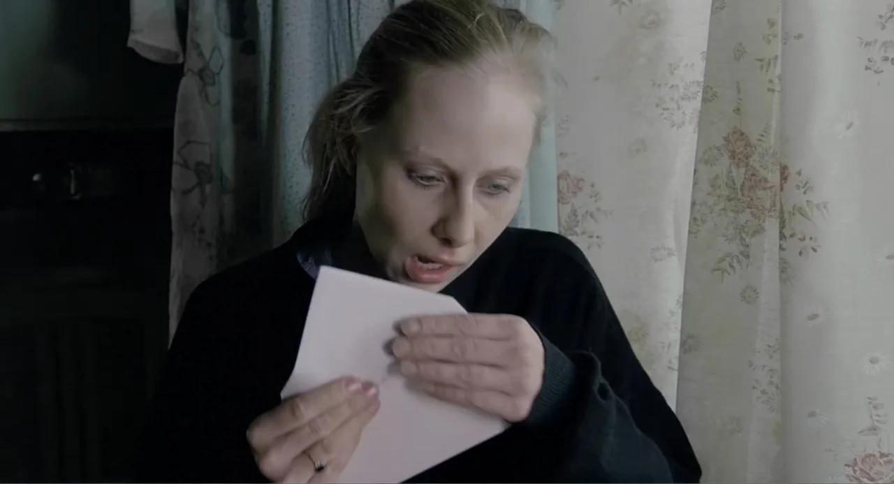 The Match Factory Girl (1990) movie still: medium — An interior space with floral pattern curtains against a window in the background. A woman in a…