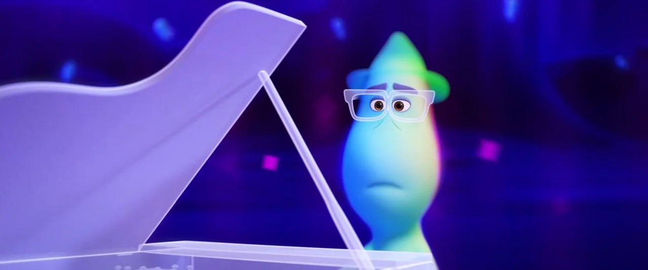Soul (2020) movie still: medium — A glowing ethereal soul stands next to a translucent grand piano in a dark void. The character gazes downward at…