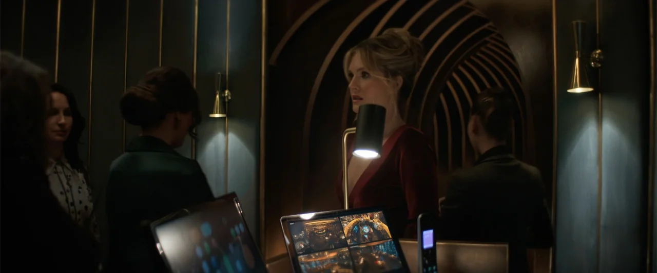Drop (2025) movie still: medium — A dimly lit lobby area features arched dark wood wall paneling and gold trim accents. A blonde woman in a red…