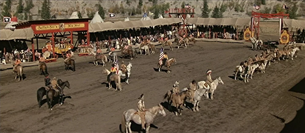 Buffalo Bill and the Indians, or Sitting Bull’s History Lesson (1976) movie still: wide — A dirt-floor Wild West arena features bleachers filled…