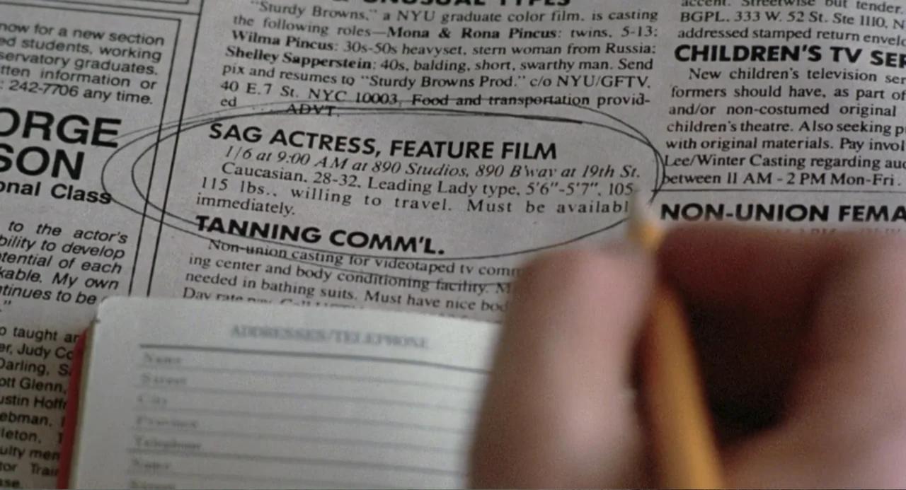 Dead of Winter (2025) movie still: closeup — A newspaper page containing classified job listings is circled with a pencil. A human hand holds a…