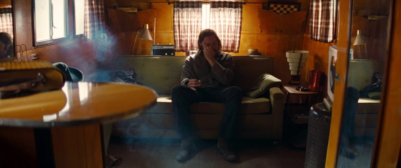 Once Upon a Time… In Hollywood (2019) movie still: medium — A wood-paneled travel trailer interior features a green sofa and period-specific decor.…