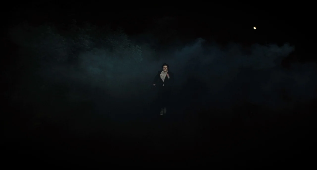 The Double (2013) movie still: wide — A man runs through a dark road shrouded in heavy, dense night fog. The surroundings are largely obscured by…