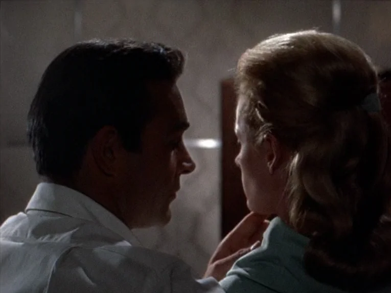Marnie (1964) movie still: closeup — An interior space contains a man and a woman in low-key lighting. The two subjects face one another in a…