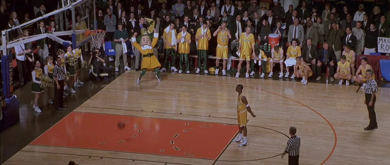Finding Forrester (2000) movie still: wide — A high-angle view of a professional basketball game in a crowded indoor arena. A single player prepares…