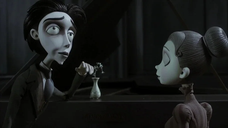 Corpse Bride (2005) movie still: medium — Two slender animated characters stand facing each other on opposite sides of a piano. A tiny vase with a…