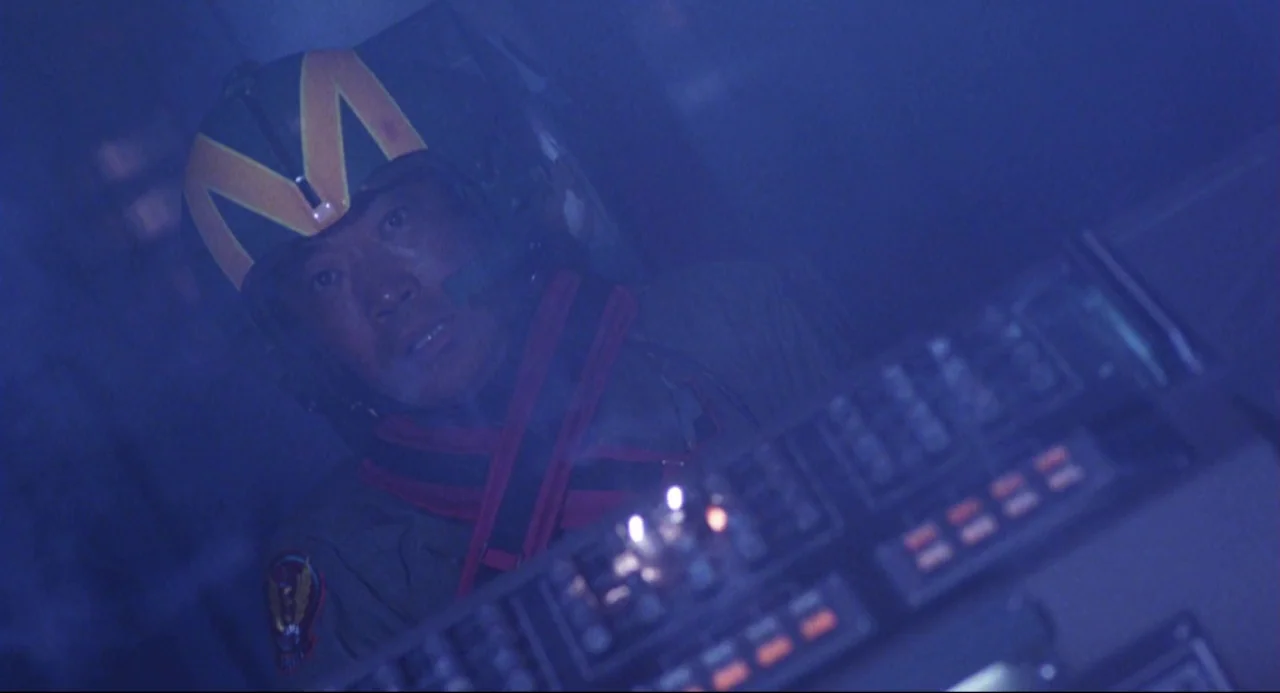 Godzilla vs. SpaceGodzilla (1994) movie still: closeup — A dimly lit interior cockpit filled with soft blue light from electronic instrumentation. A…
