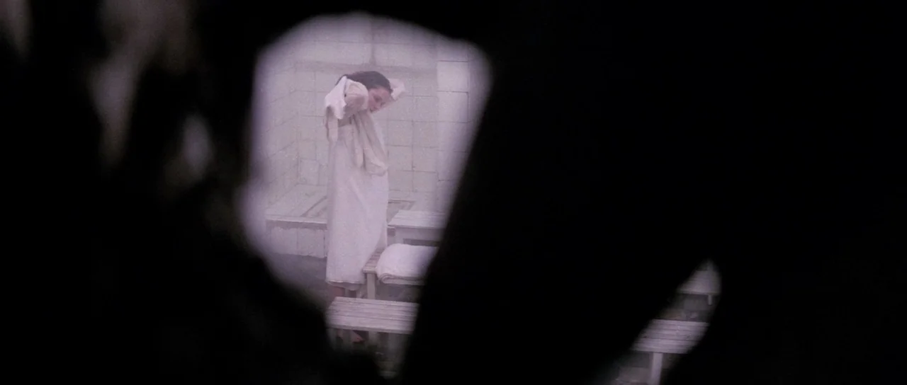 The House That Screamed (1969) movie still: medium — A tiled room with wooden benches is seen through a dark, organic frame. A woman wearing a white…