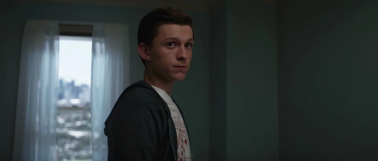 Captain America: Civil War (2016) movie still: medium — A residential room featuring a window covered with thin white curtains. A teenage boy turns…