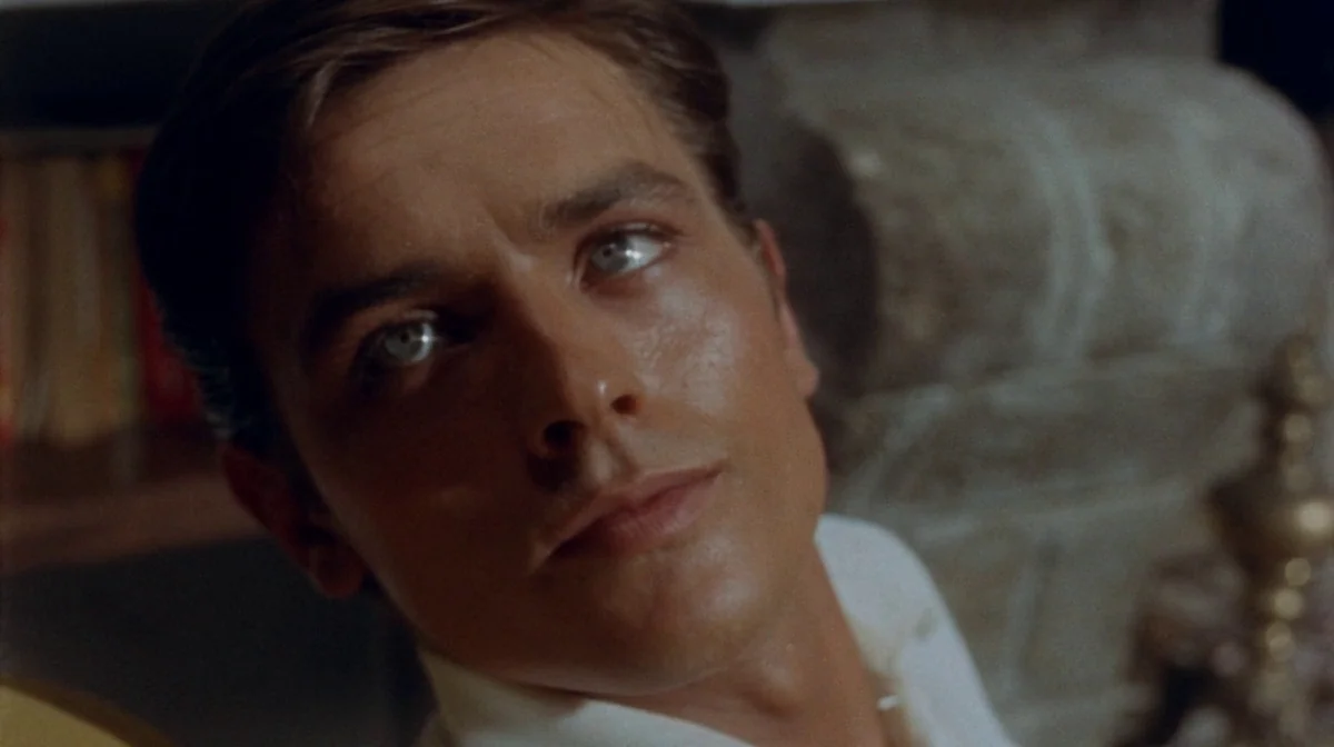 Purple Noon (Plein Soleil) (1960) movie still: closeup — A close portrait shows a young man inside a dimly lit interior room. The subject looks…
