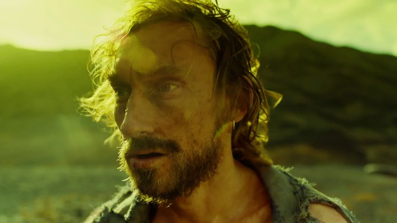 In The Heart of the Sea (2014) movie still: closeup — An arid, sun-drenched landscape with rocky, barren ground extending toward a distant, blurred…