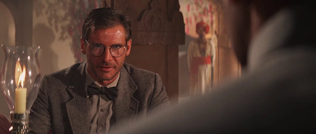 Indiana Jones and the Temple of Doom (1984) movie still: medium — A dimly lit room with ornate stone architectural details and a decorative doorway.…