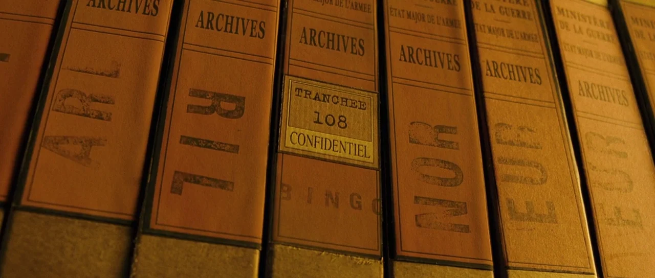 A Very Long Engagement (2004) movie still: closeup — Rows of vintage French military archive binders sit tightly packed on a wooden shelf. A…