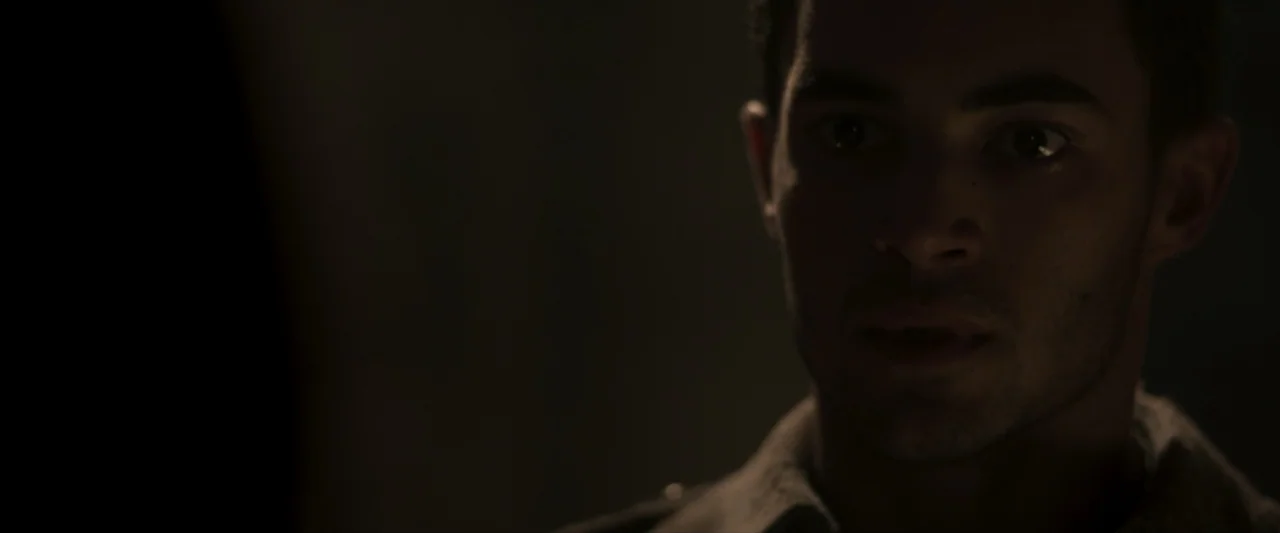 Fatima (2020) movie still: closeup — A dimly lit interior space with the subject positioned against an indistinct dark background. The subject is a…
